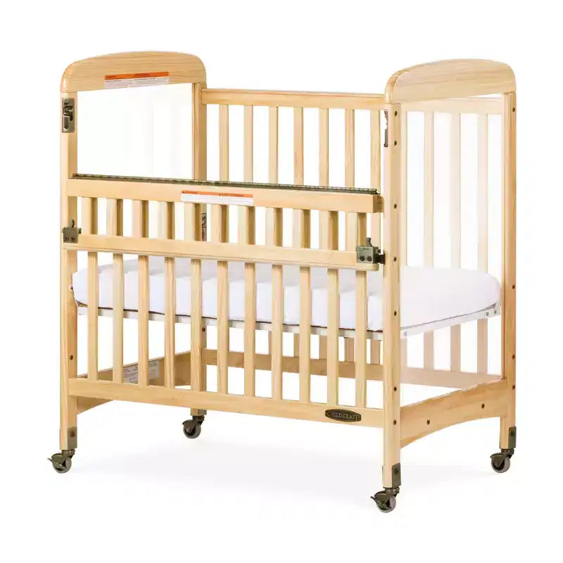 Lit de bébé portable compact en bois avec barrière SafeAccess, 2 roulettes verrouillables, panneaux ClearView, passe les portes, naturel